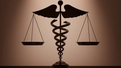Medical caduceus symbol as justice scales on a brown backdrop